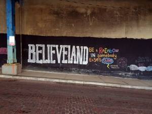 Believe Land white text painted on brown wall